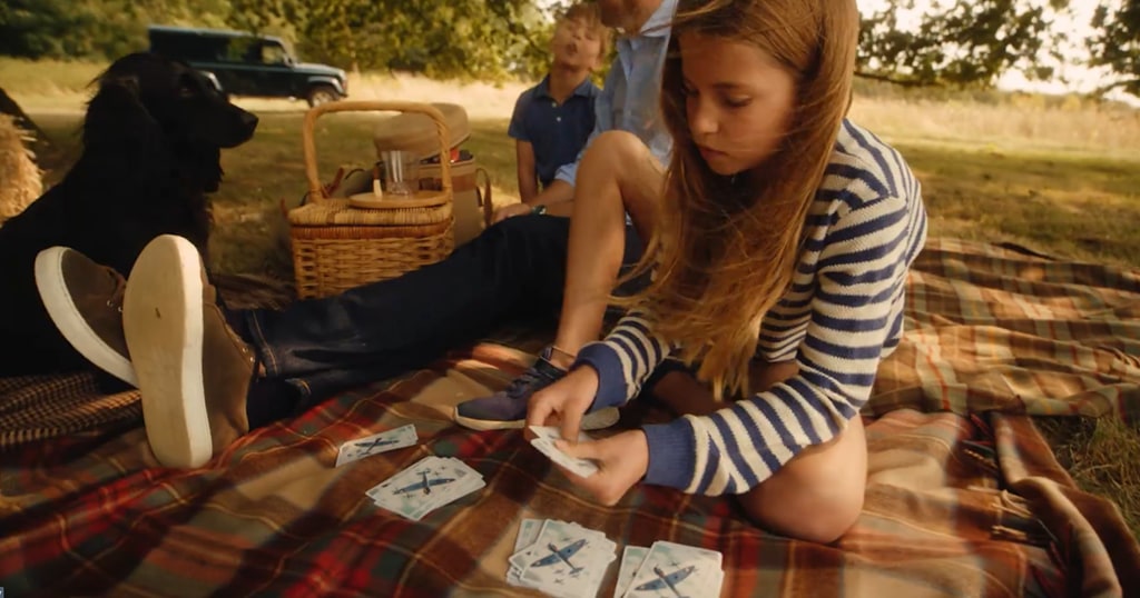 Princess Charlotte plays cards with her family on a picnic blanket 