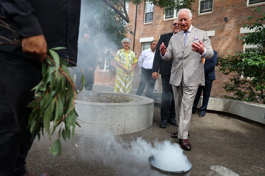 King Charles III takes part in a smoking ceremony during a visit to the National Centre for Indigenous Excellence 