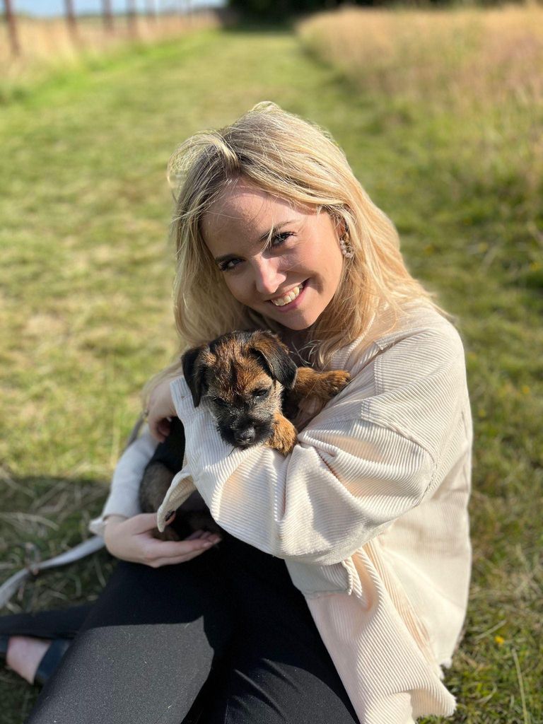 Blonde woman cuddling a puppy