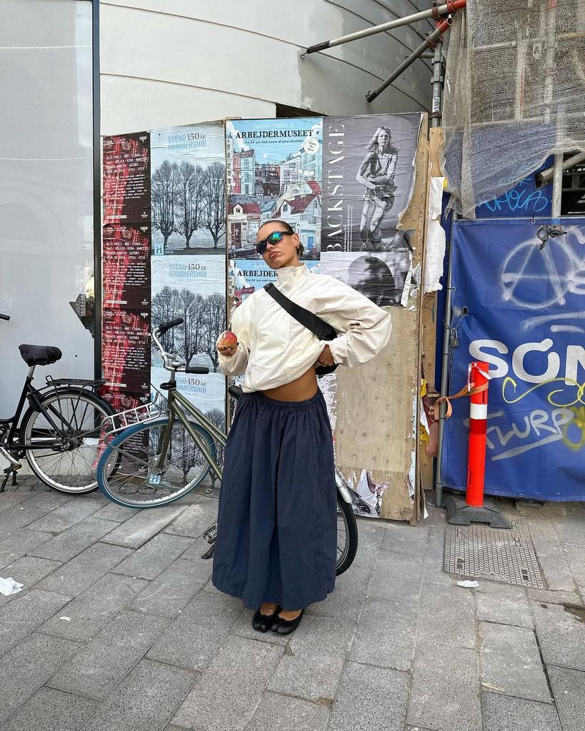 Olivia Hirst wears cream waterproof jacket with navy long skirt