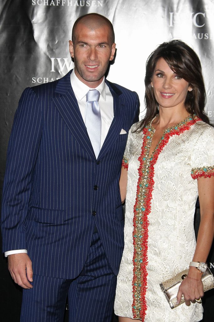 Zinedine Zidane in a blue suit and his wife Veronique in a white dress