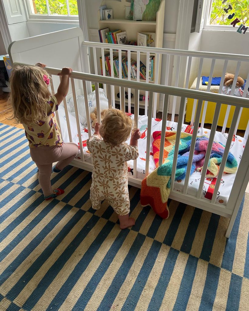 A photo of Romy and Frankie Johnson hoding onto a cot