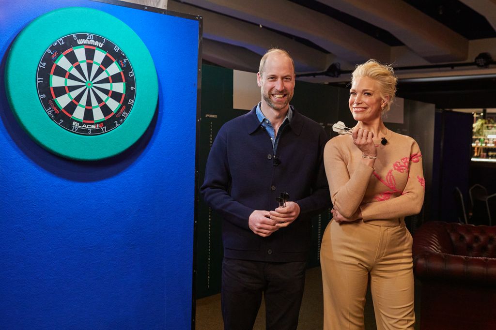 two people posing by dart board