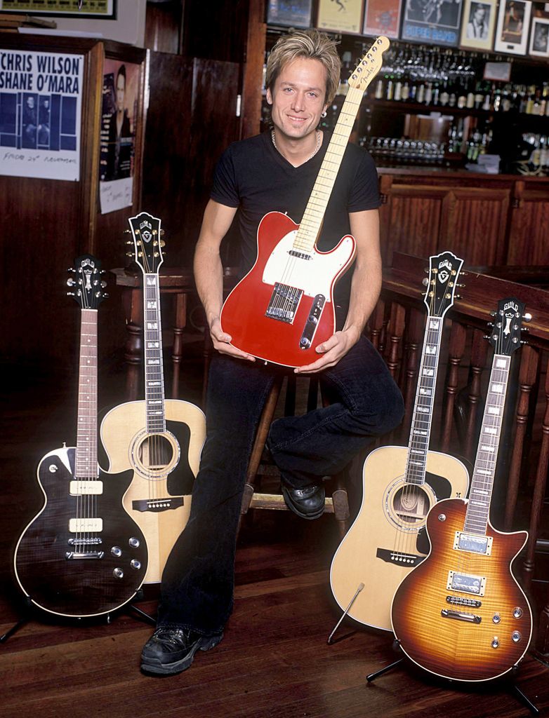 Keith Urban photographed with a guitar in November 2000
