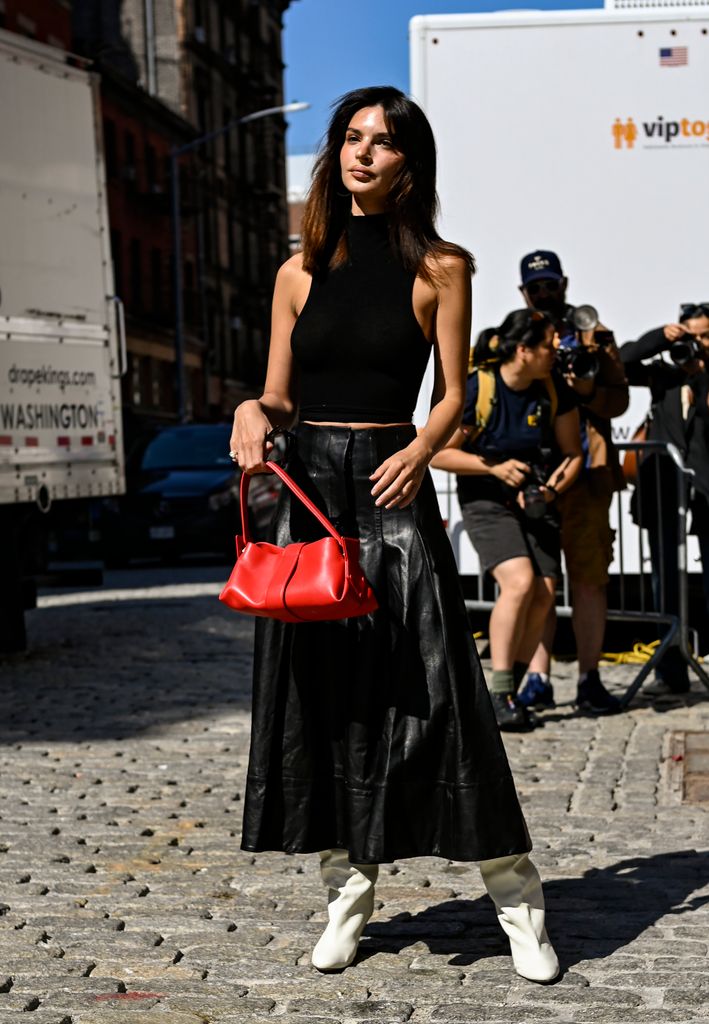 Emily Ratajkowski is seen wearing a black sleeveless top, black leather Proenza skirt, red Proenza bag and white boots outside the Proenza Schouler show on September 04, 2024 in New York City.