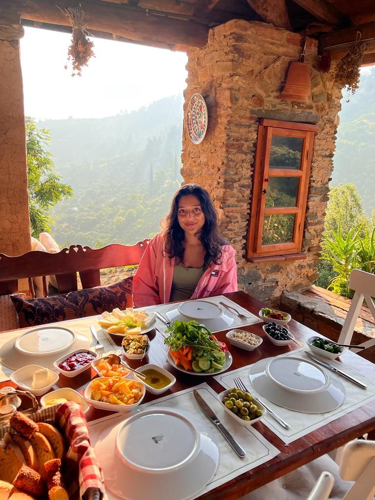 Young woman sitting at a table in amazing scenery