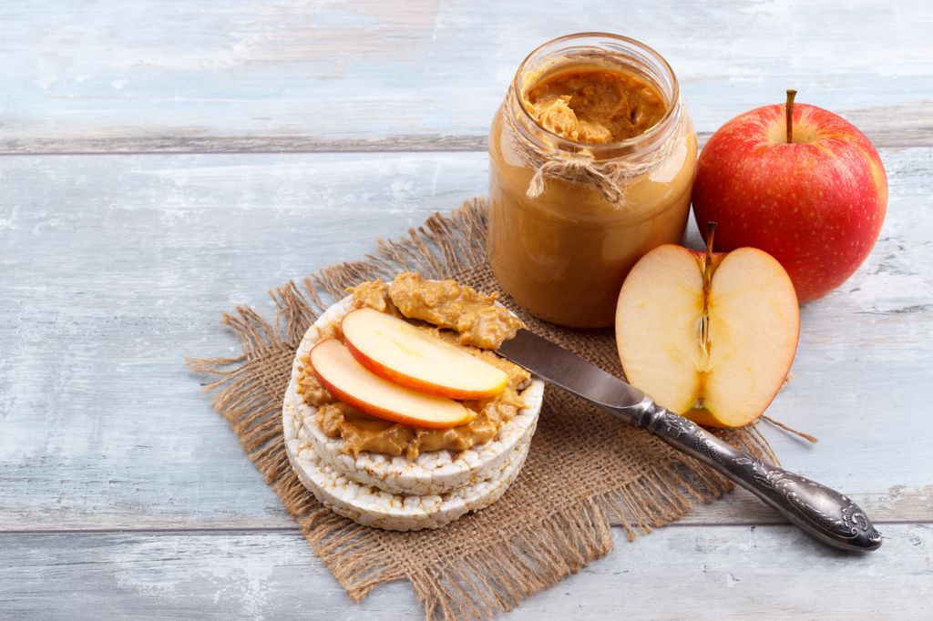 Slices of apple with peanut butter and rice crackers