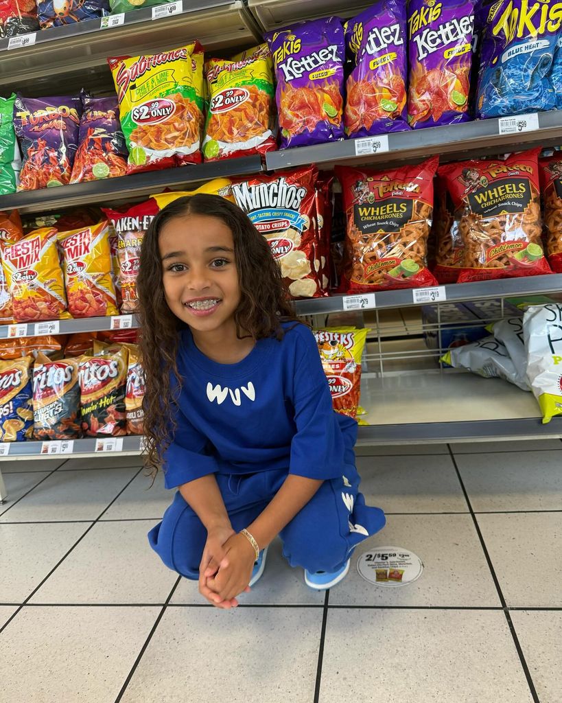 Dream Kardashian crouching on the floor in the supermarket