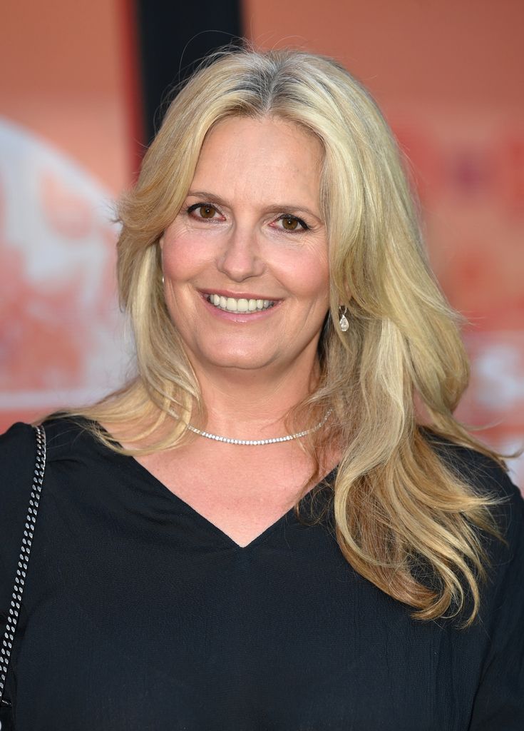 Penny Lancaster smiles waist up in black top