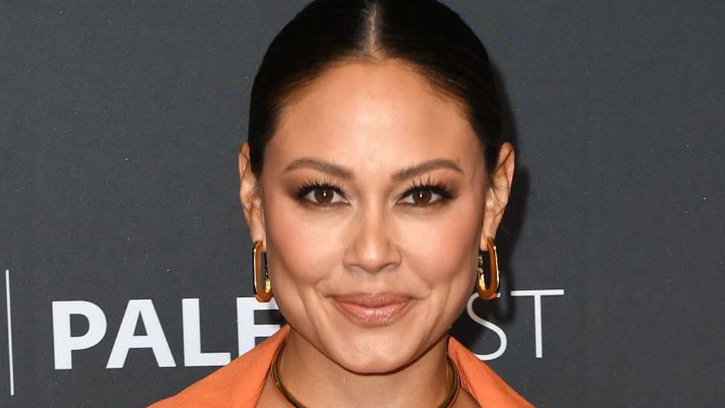 Vanessa Lachey smiling in an orange suit. 