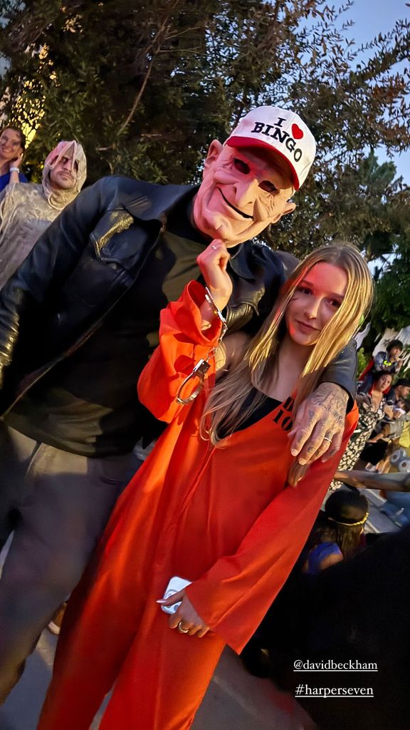 Harper Beckham in an orange jumpsuit with her dad David