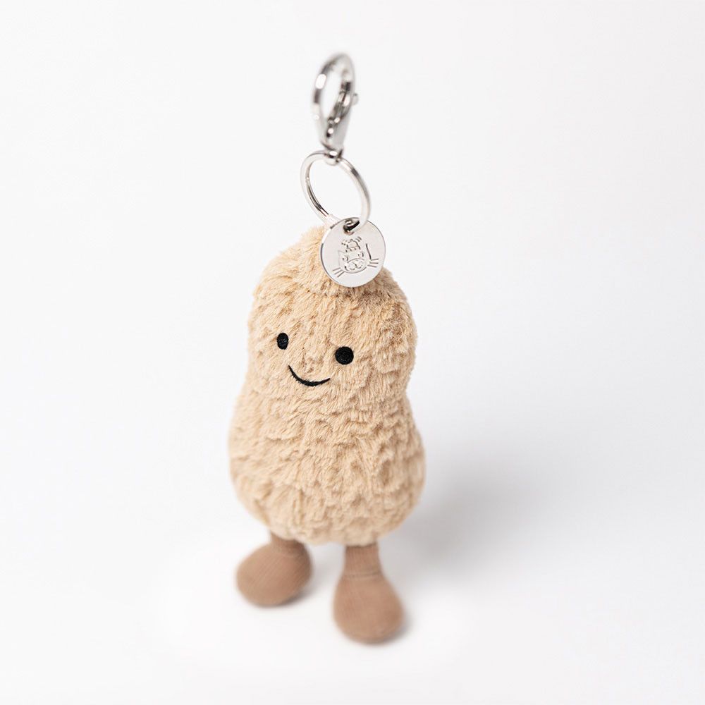 A close up of a peanut bag charm from Jellycat