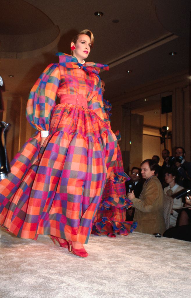 Wearing a bright checked gown for a Bill Blass runway show.