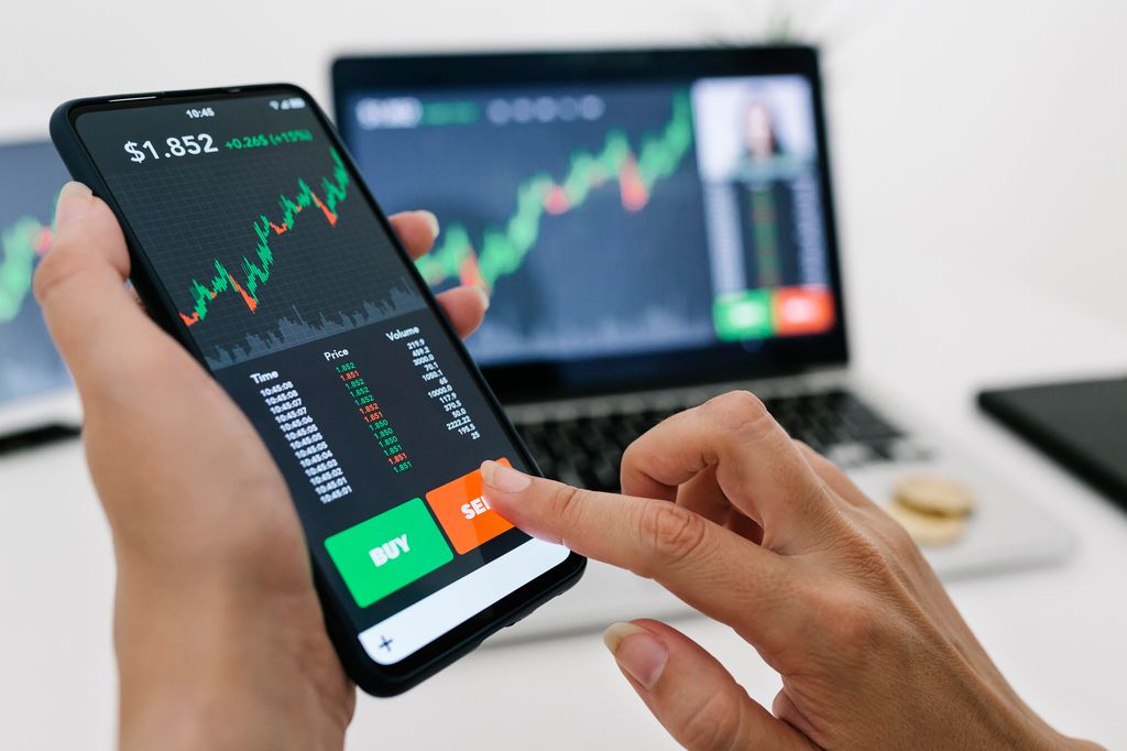 Female manager selling cryptocurrencies through mobile phone app. Stock market, investment and cryptocurrencies concept