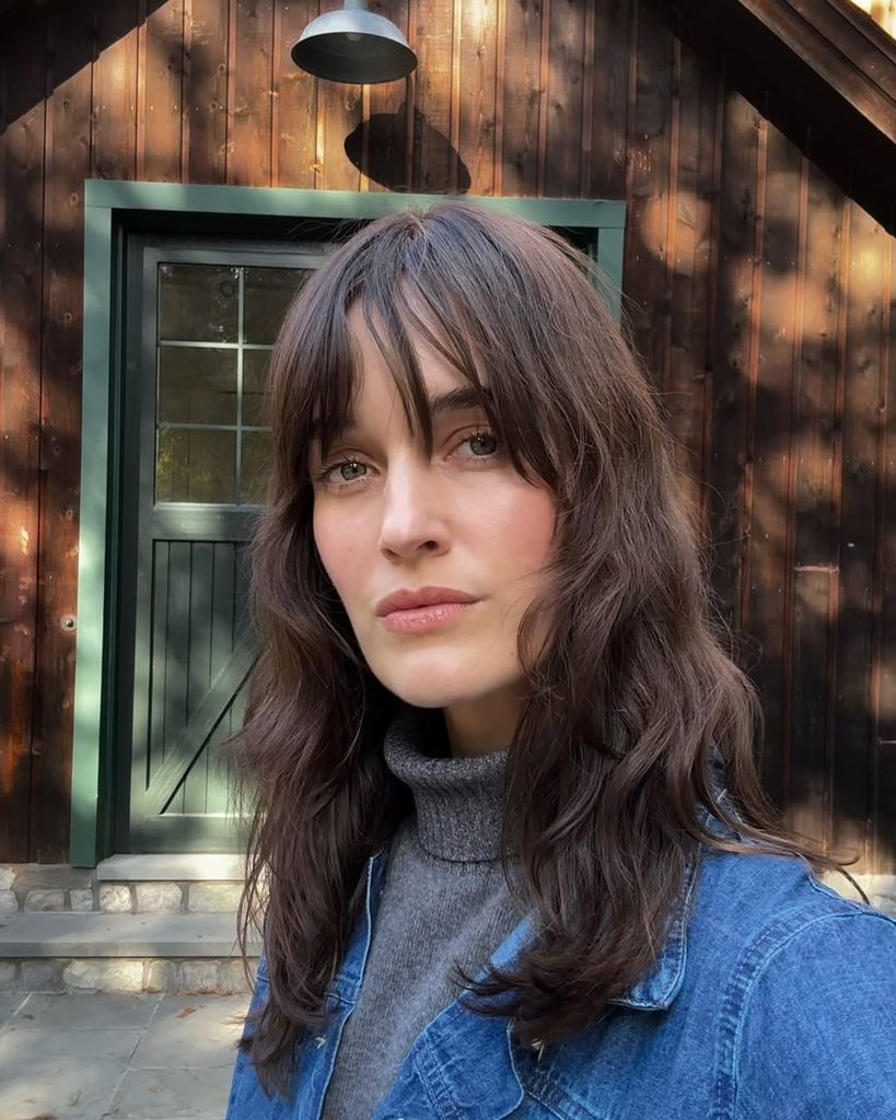 Kate Harrison posing in denim jacket and gray jumper