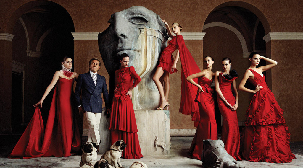 Valentino Garavani posing with just a few of his red hot creations