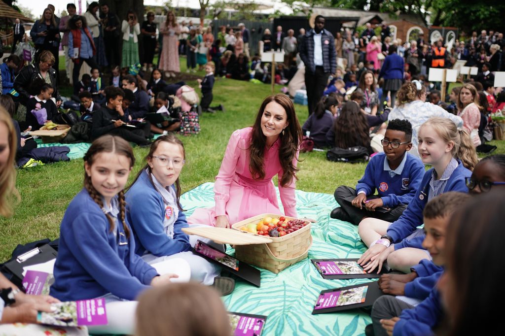 Kate Middleton sits on a picnic blanket with school children at Chelsea Flower Show