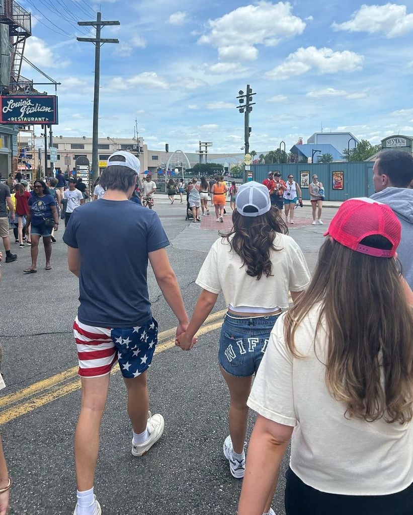 Millie and Jake walk hand in hand in Orlando enjoying their post wedding vacation