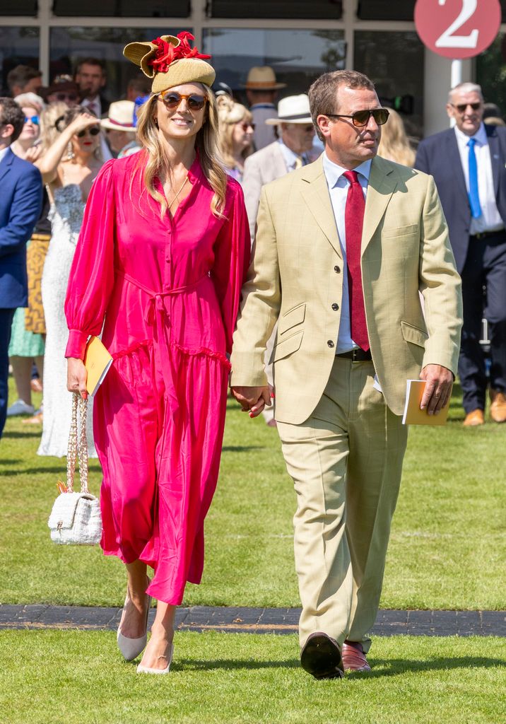 couple holding hands at horse racing event 