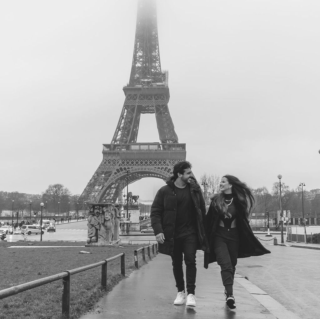 Luana Andrade and João Hadad strolling past the Eiffel Tower