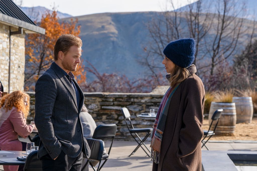 man and woman wearing coats standing opposite each other outdoors