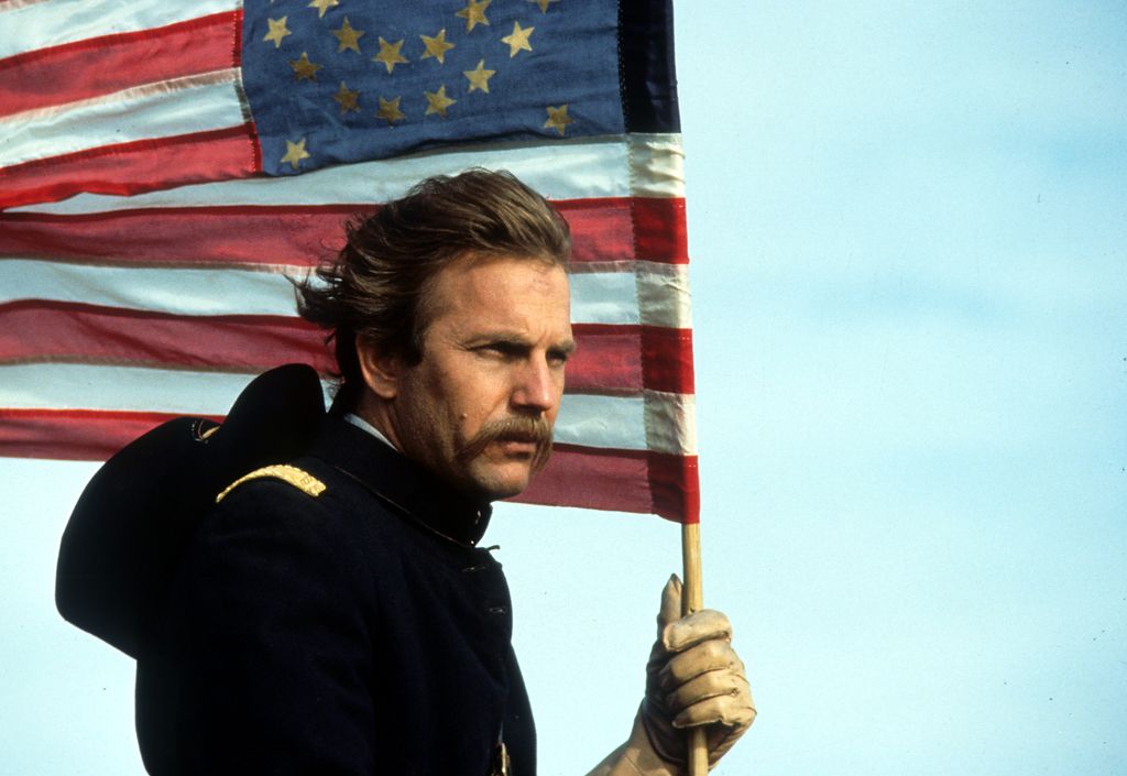 Kevin Costner holding an American flag in a scene from the film 'Dances With Wolves', 1990.