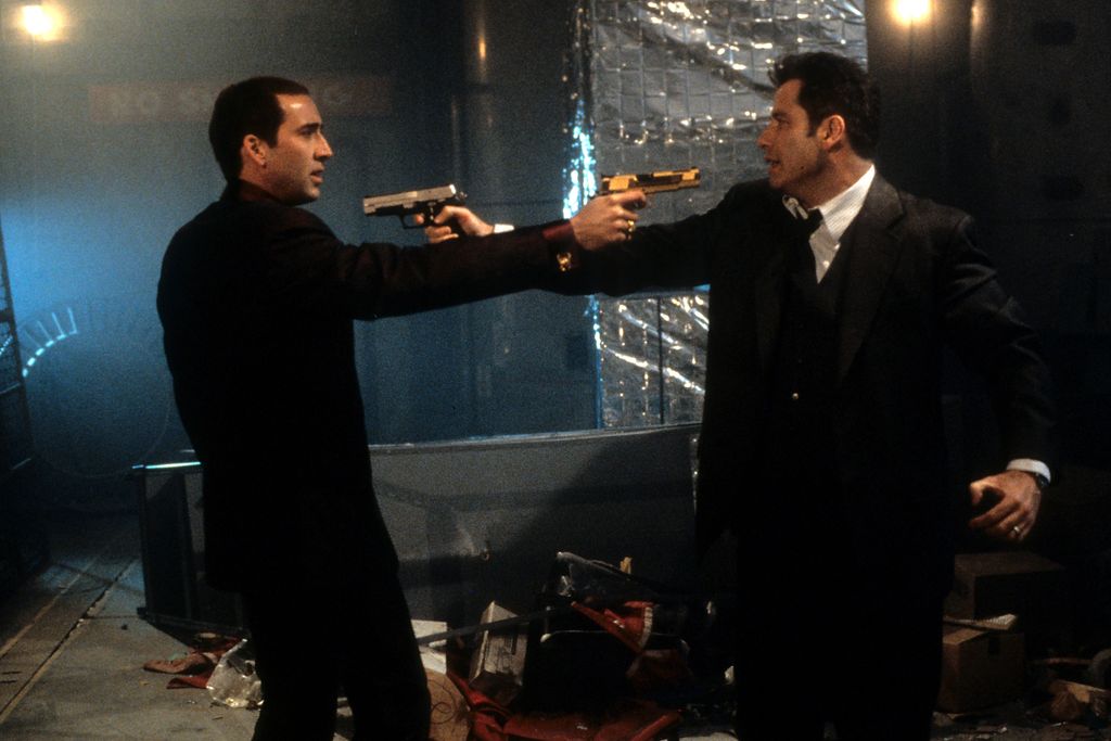 John Travolta et Nicholas Cage pointent leurs armes l'un sur l'autre.