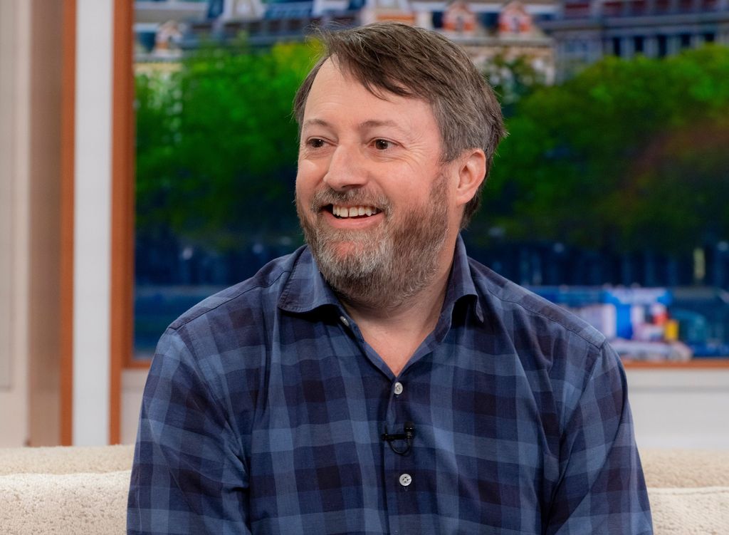 david mitchell smiling in blue check shirt