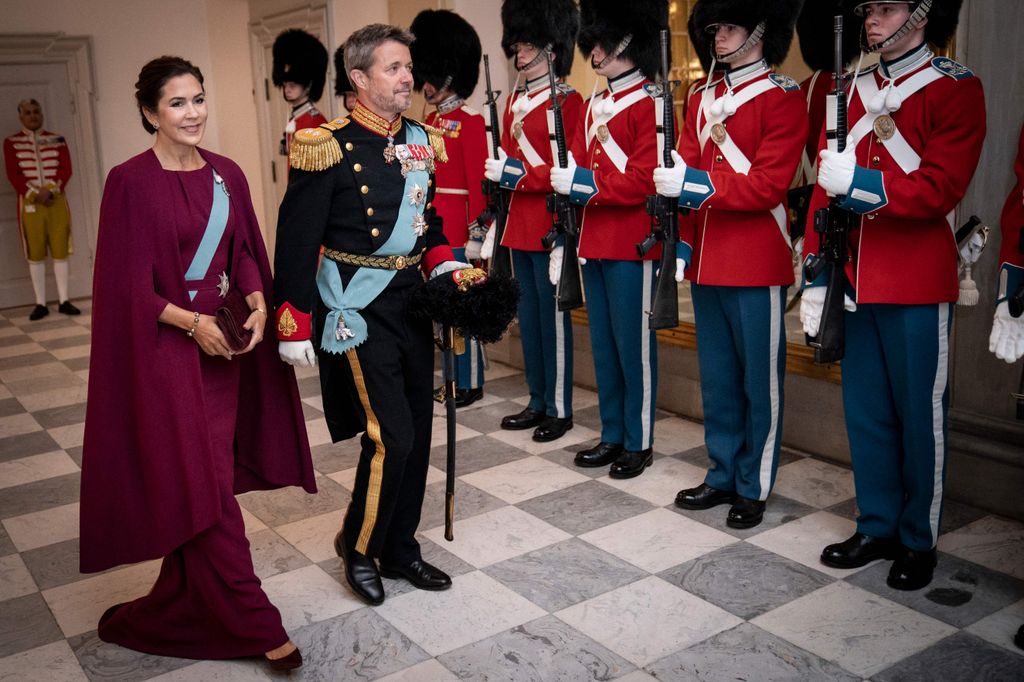 Queen Mary in burgundy dress with frederik inspecting troops