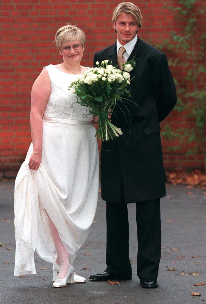 David Beckham smiling next on his sister Lynne holding a white bouquet of flowers