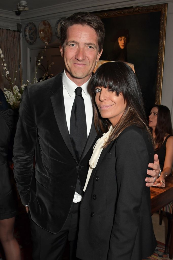 Kris Thykier in a black suit with his arm around Claudia Winkleman, also in black