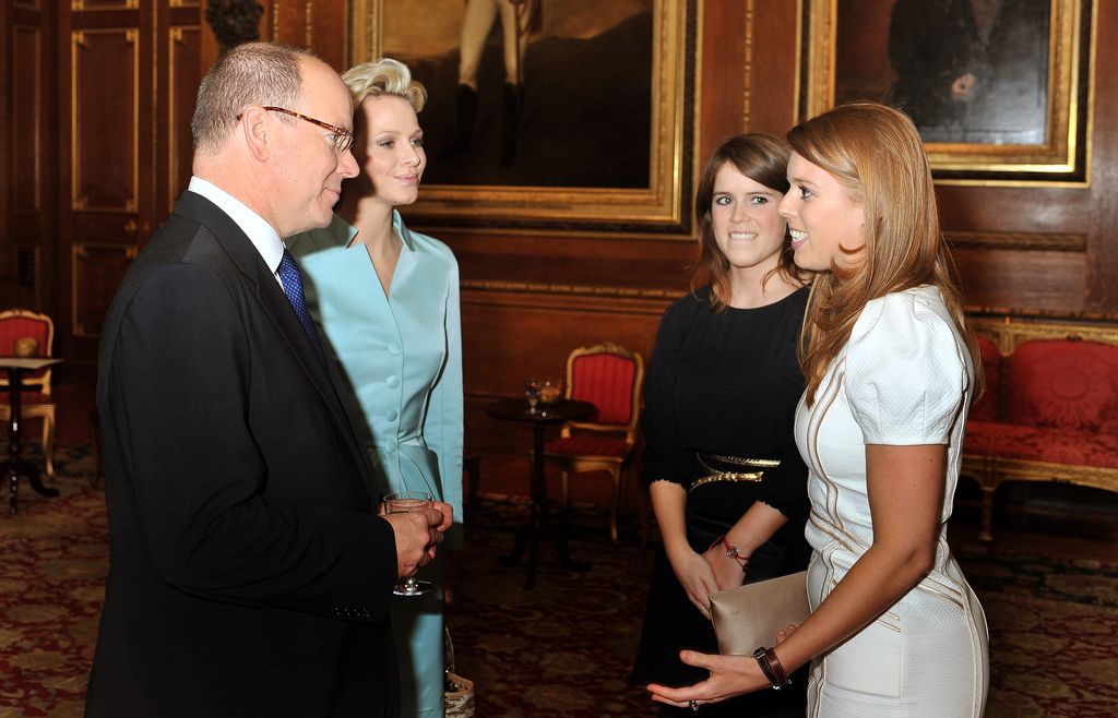 Princess Eugenie and Princess Beatrice talk to Princess Charlene of Monaco and Prince Albert II of Monaco during a reception in the Waterloo Chamber