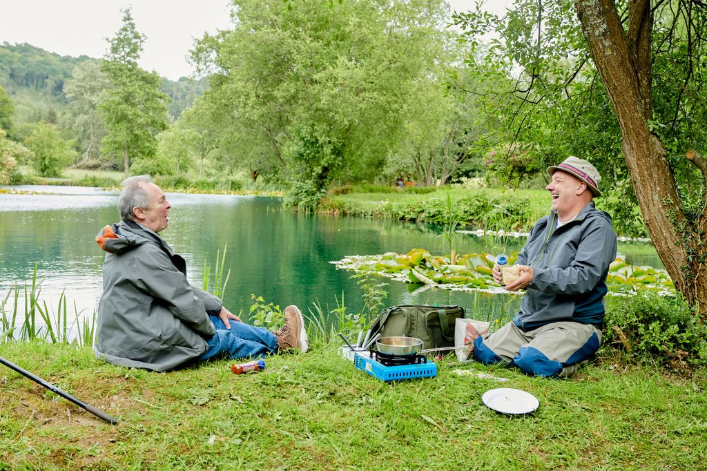 Paul Whitehouse and Bob Mortimer laughing together by a body of water