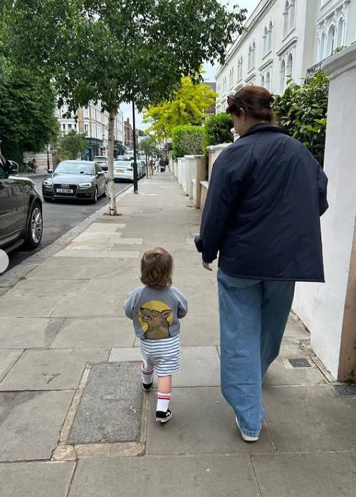 Princess Eugenie and Ernest walking alongside a street with trees and houses