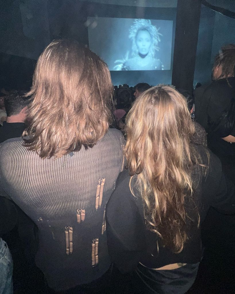 Miley and Damian from behind in black outfits