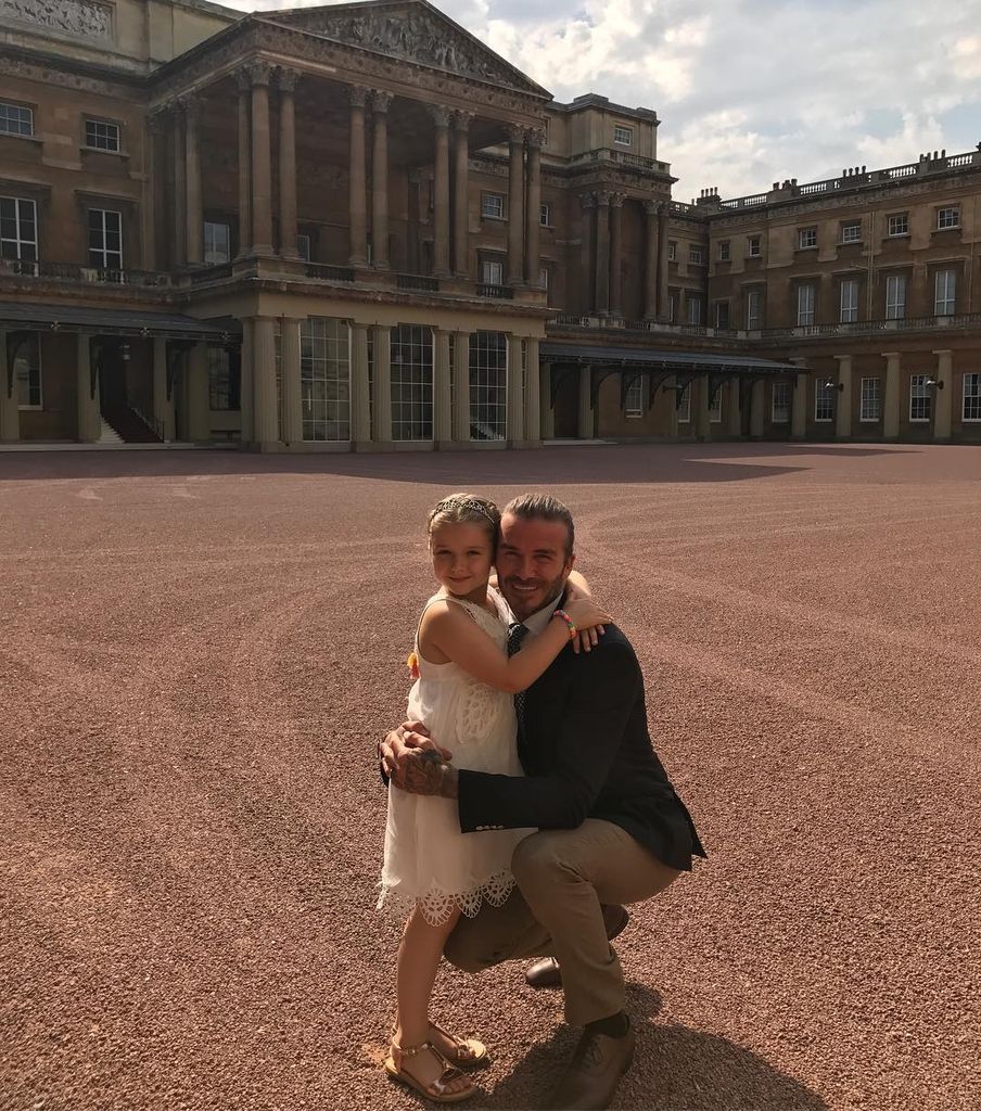 David and Harper beckham hugging posed at Buckingham Palace