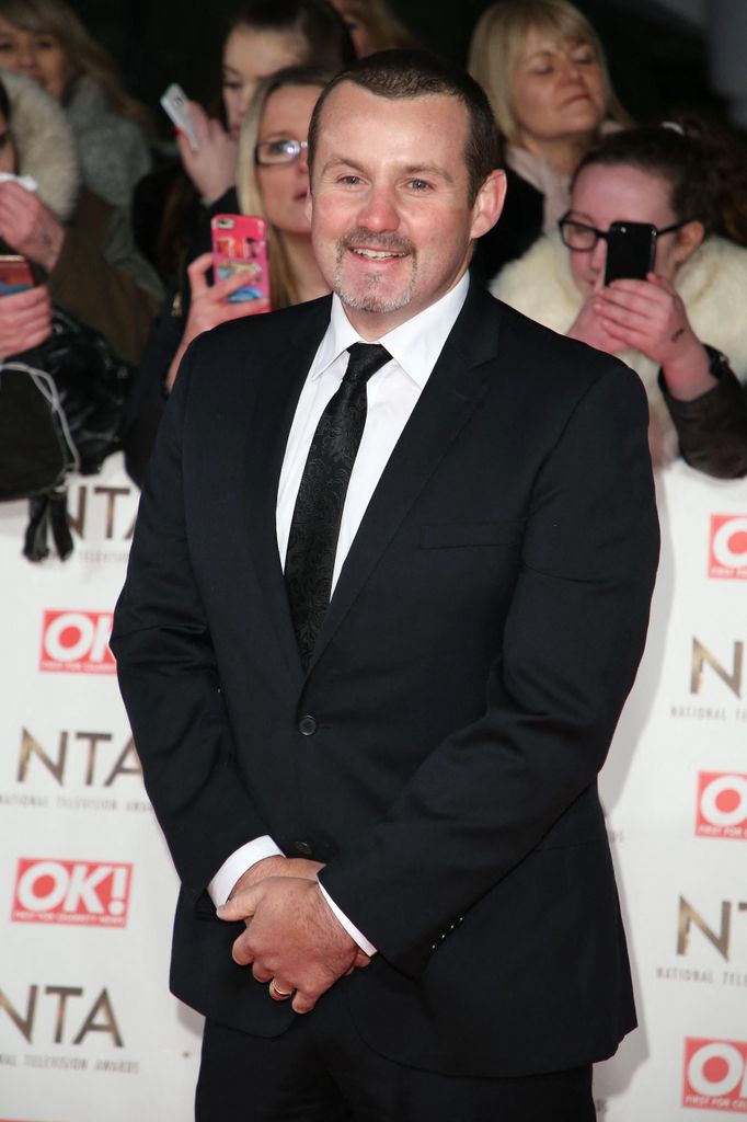 man in suit posing for photo on red carpet