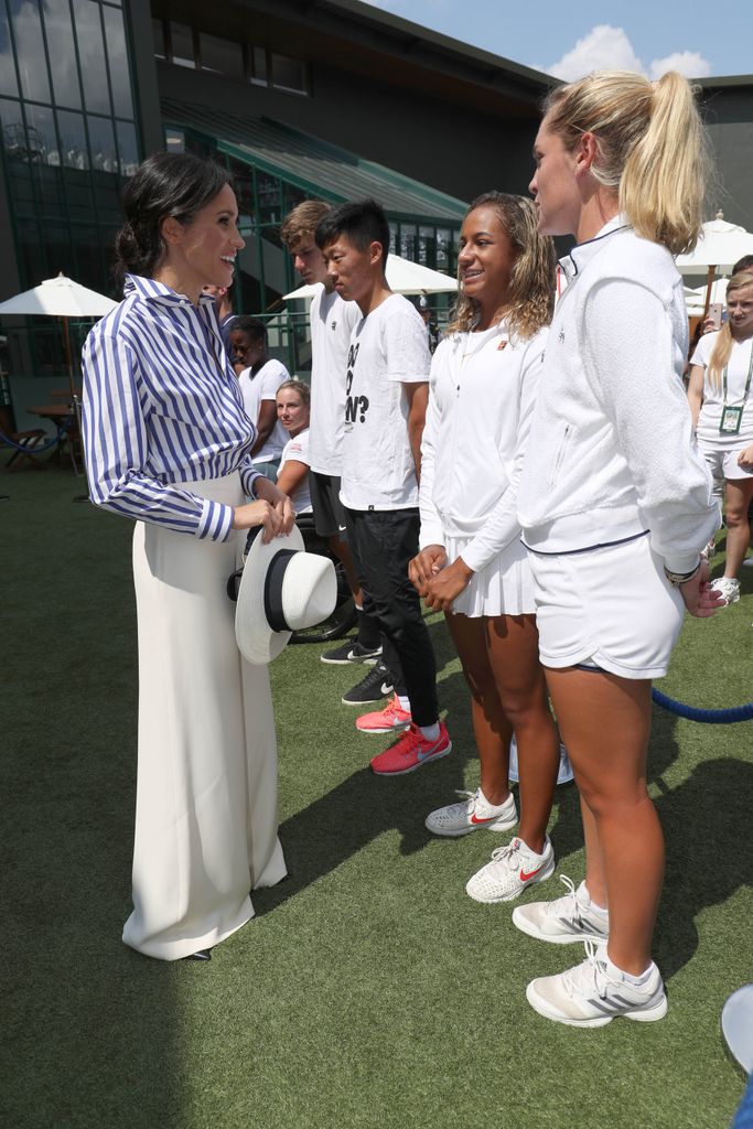 Meghan, Duchess of Sussex meets junior players Whitney Osuigwe of the United States and Caty McNally of the United States during a visit to the Wimbledon Championships at All England Lawn Tennis and Croquet Club on July 14, 2018 in London, England. (Photo by Jonathan Brady - WPA Pool/Getty Images)