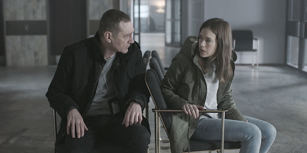 man and woman sitting in chairs in empty room