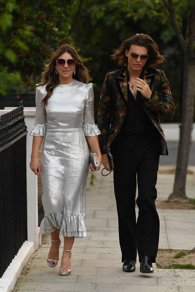 Elizabeth Hurley e Damian Hurley em Londres usando um vestido prateado