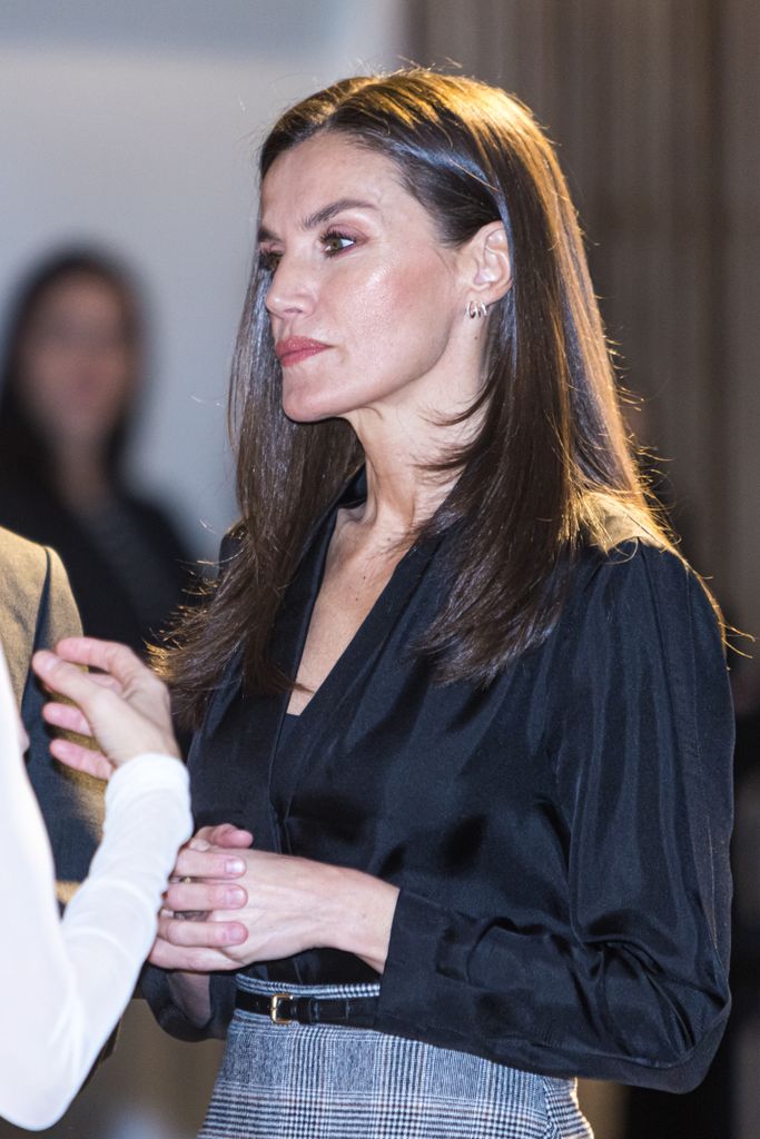 Queen Letizia from side engaged in conversation