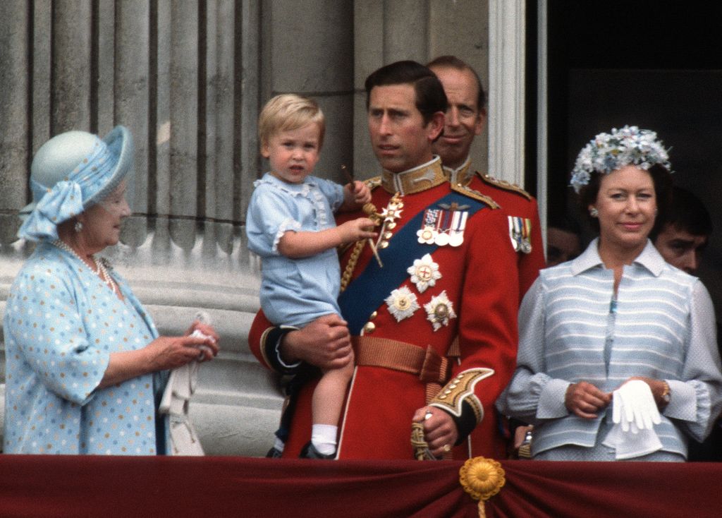 Prince Charles holding William on balcony