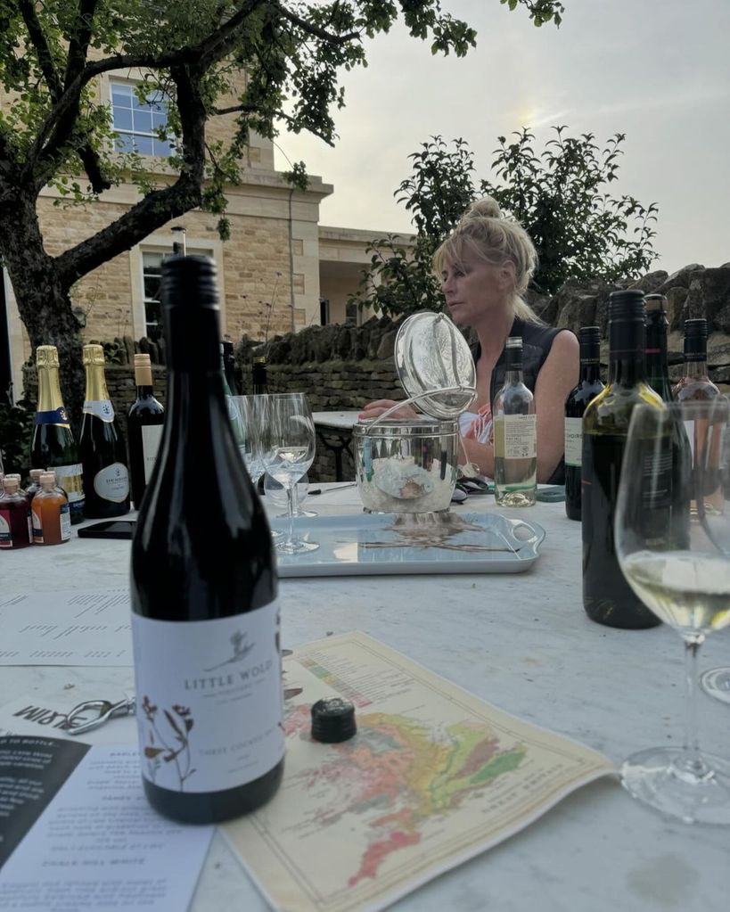 Jeremy Clarkson sitting at a table with a wine bottle