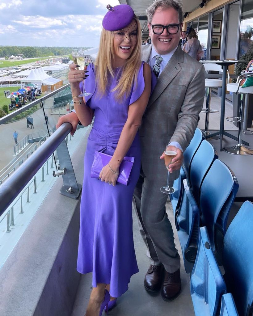 Amanda Holden poses with Alan Carr at Royal Ascot. She is wearing an £850 dress from Victoria Beckham's collection