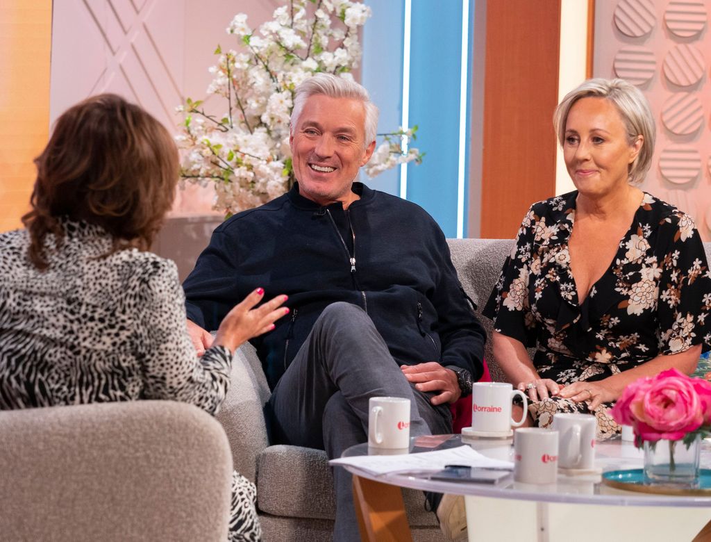 Martin Kemp smiling next to wife Shirlie in a floral dress