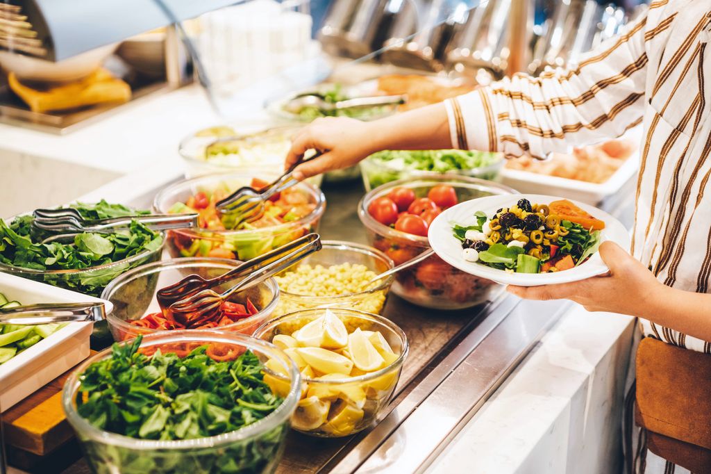 Woman choosing food for breakfast at hotel restaurant