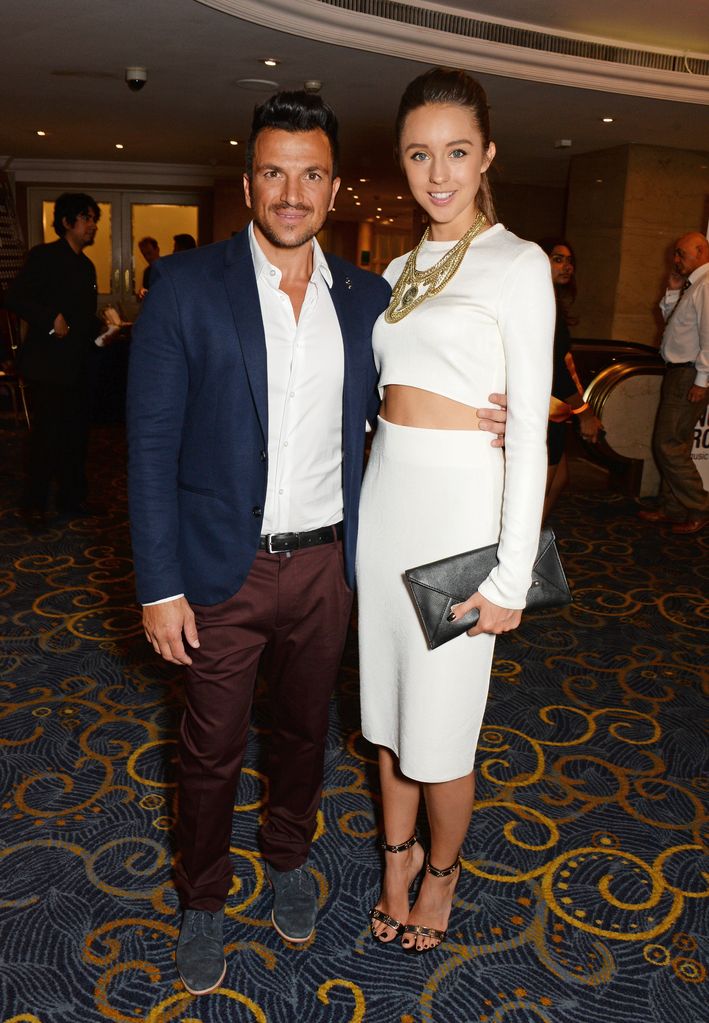 Peter Andre in a blue suit and his wife Emily in a white dress