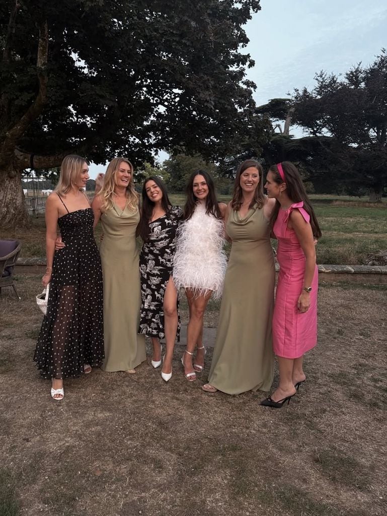 Fashion Tech Journalist and The Modems founder Natalie Salmon wears pink dress and black sunglasses standing at a wedding with bride and friends