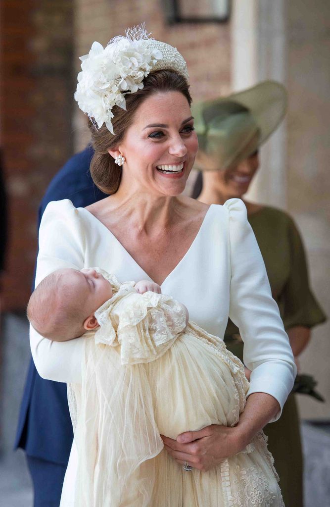 Britain's Catherine, Duchess of Cambridge holds Britain's Prince Louis of Cambridge on their arrival for his christening service wearing Alexander McQueen dress
