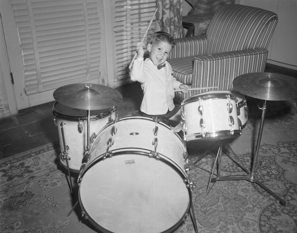 Keith Thibodeaux of Bunkie, Alabama, at the age of 3 has a contract with Horace Heidt's orchestra. His mania for beating time began when he saw a parade when he was just 1 1/2. Keith is shown practicing a few hot licks on man-sized drums in the cottage he shares with his parents and two sisters on Heidt's Sherman Oaks, California, ranch, 1955